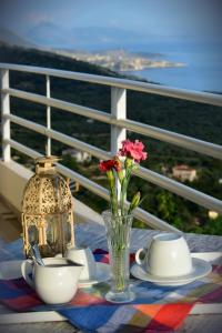 a table with plates and cups and a vase with flowers at Villa Filip in Vuno