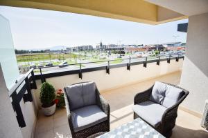 two chairs on a balcony with a view of a highway at Your Home at Coresi Mall in Braşov