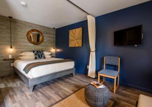 1 dormitorio con paredes azules, 1 cama y 1 silla en Treehouse Lodge, en Woods Hole