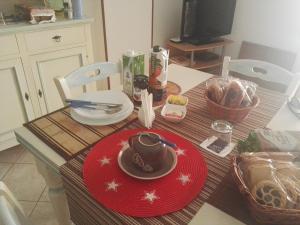 una mesa con un plato rojo de comida en ella en B&B Shardana, en Alghero