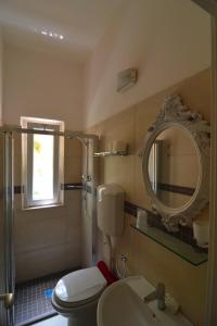 a bathroom with a toilet and a sink and a mirror at Hotel VistaMare Viserba in Rimini