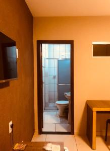 een badkamer met een toilet en een douche bij Dok Brasília Hotel Unidade Águas Claras in Taguatinga