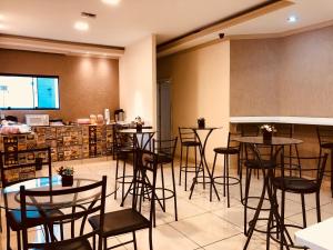 a restaurant with tables and chairs and a counter at Dok Brasília Hotel Unidade Águas Claras in Taguatinga