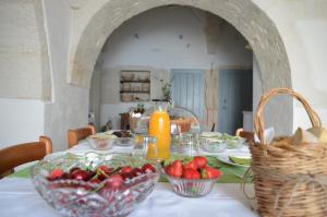 a table with bowls of strawberries and a jug of orange juice at Masseria Faraone in Martina Franca