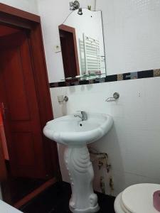 a bathroom with a white sink and a toilet at Pensiunea Balea in Cîmpeni