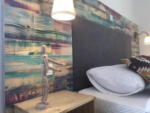 a man standing on a table next to a bed at Boho House in Pakoštane