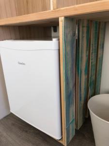 a white dishwasher under a shelf in a room at Boho House in Pakoštane