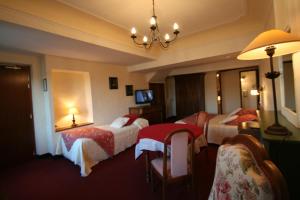 a hotel room with two beds and a television at Hostellerie Le Beffroi in Vaison-la-Romaine