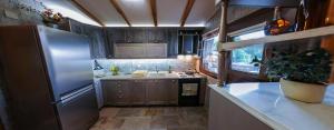 a kitchen with a stainless steel refrigerator and a sink at The StoneHouse in Keramídhion