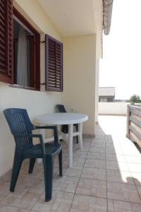 una mesa blanca y sillas en un patio en Apartment Dede, en Nin