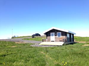 a small house on a hill in a field at Midholl guesthouse in Ásmundarstaðir