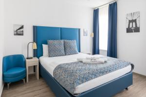 a blue and white bedroom with a bed and a blue chair at Residence Mutschellen in Zürich