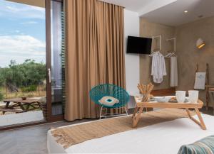 a living room with a table and a chair at Vintage Suites in Limenaria