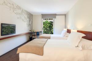 a hotel room with two beds and a window at Hotel Ismael - Lastarria in Santiago