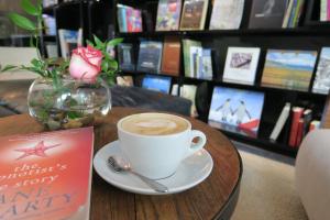 una tazza di caffè seduta su un tavolo con un libro di Hotel Ismael a Santiago