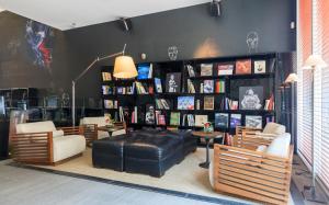 a living room with a leather ottoman and chairs and books at Hotel Ismael in Santiago