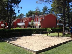 een basketbalveld voor een rood gebouw bij Adriella apartments in Bibione