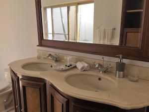 La salle de bains est pourvue d'un lavabo et d'un miroir. dans l'établissement Hotel Boutique Villa Casuarinas, à Cali