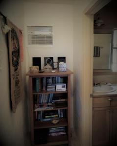 a book shelf with books and a sink in a bathroom at Kehena Beach Getaway in Kehena