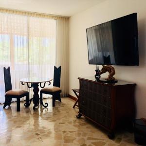 a living room with a television on top of a dresser at Hotel Boutique Villa Casuarinas in Cali