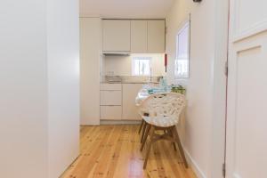 uma cozinha com uma mesa e uma cadeira num quarto em APOSENTUS - Your home with a remarkable view em Vila Nova de Gaia