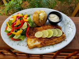 un piatto di cibo con pesce e insalata e salsa di Casita Océana a Sandy Bay