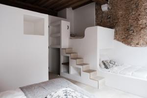 a white bedroom with a staircase and a bed at Boutique Holiday Home ZaligInAntwerpen 77 in Antwerp