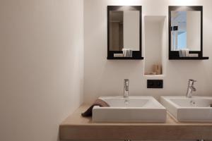 a bathroom with two sinks and two mirrors at Boutique Holiday Home ZaligInAntwerpen 77 in Antwerp +43 photos