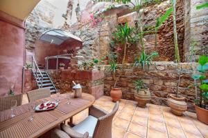 a patio with a table and chairs and plants at Casa Kasteli in Chania Town