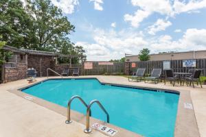 a swimming pool with patio furniture and chairs around it at Microtel Inn and Suites by Wyndham Anderson SC in Anderson