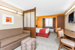 um quarto de hotel com uma cama, um sofá e uma mesa em Microtel Inn and Suites by Wyndham Anderson SC em Anderson