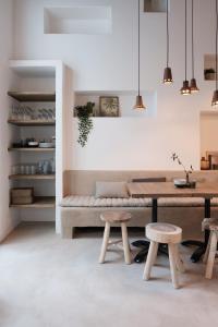 a dining room with a table and two stools at Boutique Holiday Home ZaligInAntwerpen 77 in Antwerp