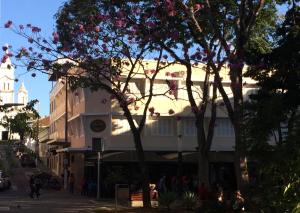 a large white building with pink flowers on it at Hotel Centenario Itajuba in Itajubá
