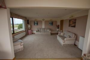 a large living room with couches and a large window at Golfview in Buckie