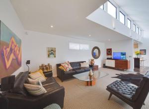 a living room with two couches and a table at Black Luxury Lodge in Blenheim