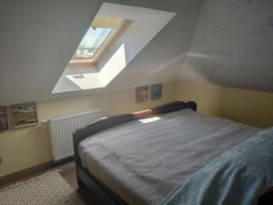um quarto com uma cama e uma clarabóia em Pokoje na Jasnej em Colberga
