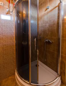 una doccia con porta in vetro in bagno di Hotel Simpatia a Kobuleti