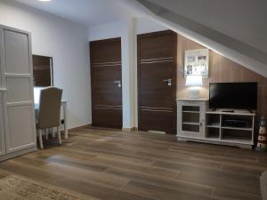 a living room with wooden doors and a television at Pokoje na Jasnej in Kołobrzeg