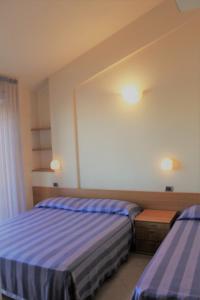 una camera con due letti e due luci sul muro di Residence Myricae a Bellaria-Igea Marina