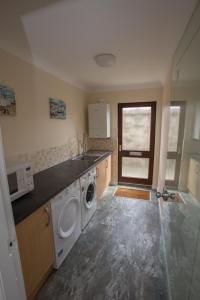 a kitchen with a sink and a washing machine at Golfview in Buckie