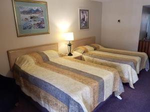 A bed or beds in a room at Slumber Lodge Williams Lake