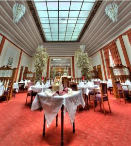 uma sala de jantar com mesas com toalha de mesa branca em The Lucan Spa Hotel em Lucan