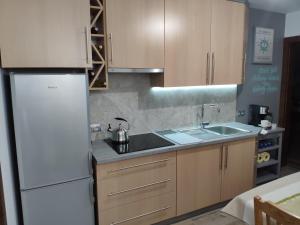 a kitchen with a white refrigerator and a sink at Pokoje na Jasnej in Kołobrzeg