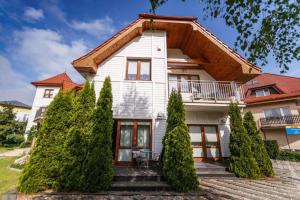 a white house with trees in front of it at Willa Vela in Władysławowo