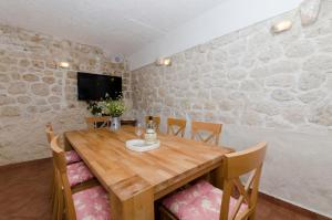a dining room with a wooden table and chairs at House Jasna in Igrane