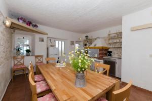 a dining room table with a vase of flowers on it at House Jasna in Igrane