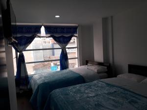 1 dormitorio con 2 camas y ventana en Hotel Royal Class en Ipiales