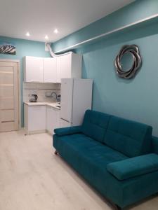 アドレルにあるElite House Sochi 3のリビングルーム(青いソファ付)、キッチン