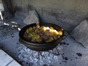a pan filled with food cooking in a fire at Apartmani Vinici in Danilovgrad