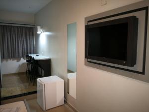 um quarto com uma televisão de ecrã plano na parede em Brasilia Parque Hotel em São Paulo